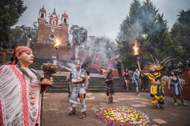 İspanyol öncesi kostümlü dansçılar, bahar ayini sırasında Meksika 'nın Metepec kentindeki Calvary Merdivenleri' ndeki tören için meşalelerini yakarak ritüel danslarını yapıyorlar..