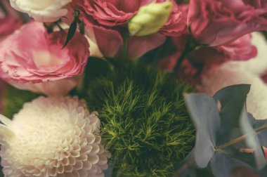 Süslü bitkilerle dolu pembe ve beyaz bir buket çiçeğin ayrıntıları.