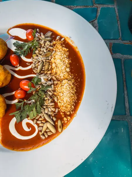 Kızarmış muz molotlarının ayrıntıları yanında peynir, krema, ayçiçeği tohumu ve vişne domatesli kırmızı köstebek..