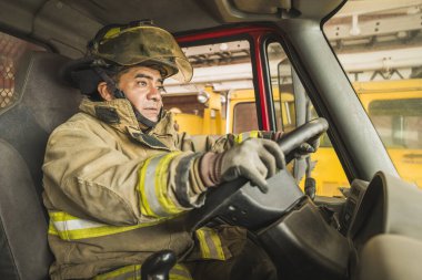 İtfaiyeci yangına müdahale etmek için kamyon kullanıyor..