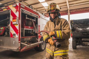 Cesur itfaiyeci tanker kamyonunun su hortumunu hazırlayarak yangını destansı bir şekilde söndürmeye çalışıyor..