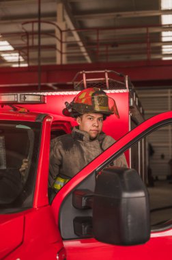 İtfaiyeci. Yangın söndürme çağrısına gitmek için kamyona biniyor..