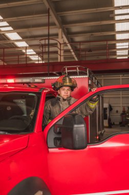 İtfaiyeci. Yangın söndürme çağrısına gitmek için kamyona biniyor..