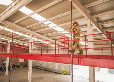 Cesur itfaiyeci, yatakhaneden kamyon alanına gidip yangını söndürmek için metrodan atlamak üzere..