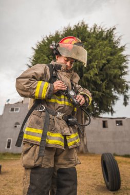 Cesur itfaiyeci hava tankı teçhizatını ve diğer ekipmanlarını giyip bir yangınla savaşmaya gitti..