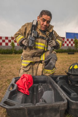 Cesur itfaiyeci hava tankı teçhizatını ve diğer ekipmanlarını giyip bir yangınla savaşmaya gitti..