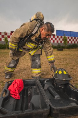 Cesur itfaiyeci hava tankı teçhizatını ve diğer ekipmanlarını giyip bir yangınla savaşmaya gitti..