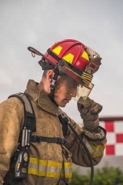 Mısır kökenli cesur itfaiyeci kaskını takıyor ve ayarlıyor. Yangını söndürmeye hazır..