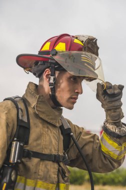 Mısır kökenli cesur itfaiyeci kaskını takıyor ve ayarlıyor. Yangını söndürmeye hazır..