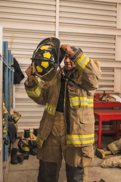 Cesur itfaiyeci asbest kıyafetini, özel botlarını ve diğer ekipmanlarını giyer..
