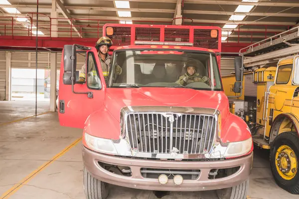 İtfaiyeci. Yangın söndürme çağrısına gitmek için kamyona biniyor..