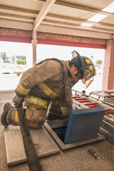 İtfaiyeci suyu bir tanker kamyonuna yüklüyor..