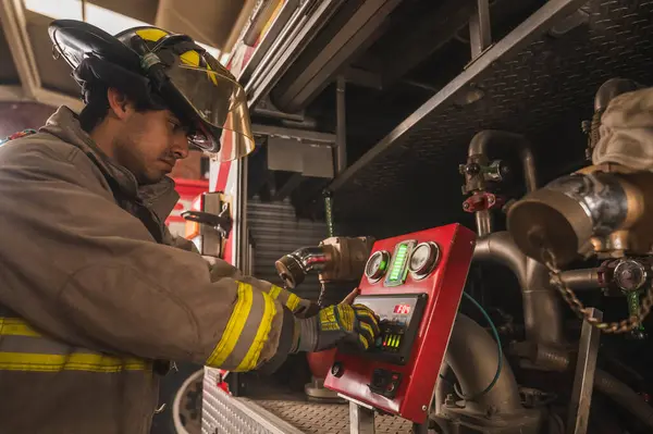 İtfaiyeci, tankerin su pompasını yangını söndürmek için hazırlıyor..
