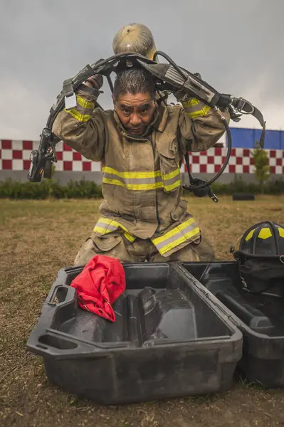 Cesur itfaiyeci hava tankı teçhizatını ve diğer ekipmanlarını giyip bir yangınla savaşmaya gitti..