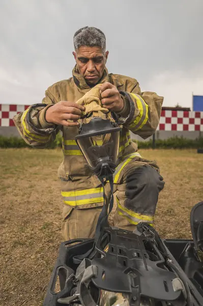 Cesur itfaiyeci duman ve gaz maskesi takıp öne doğru eğiliyor..