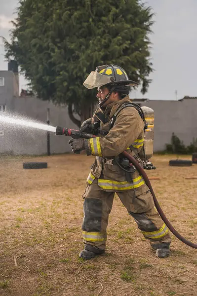 Cesur itfaiyeci, su perdesinin arkasında destansı bir duruşta durup yangını söndürüyor..