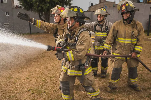 Dört cesur itfaiyeci su perdesinin arkasında durup yangını söndürüyorlar..