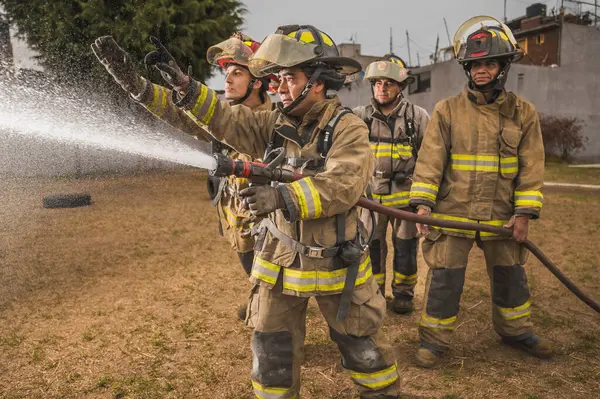 Dört cesur itfaiyeci su perdesinin arkasında durup yangını söndürüyorlar..