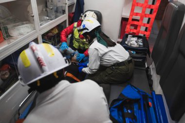 Latin sağlık görevlileri, hava pompasını ve oksijen ölçümünü kullanarak ambulansın içinde bir hastaya ilk yardım sağlıyor..