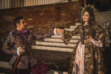 İspanyol sömürgesi döneminden flört eden bir çift, geleneksel İspanyol takım elbiseli bir adam mor ve pembe giyinmiş bir adam, ve prenses tarzı bir tacı olan güzel bir kız..