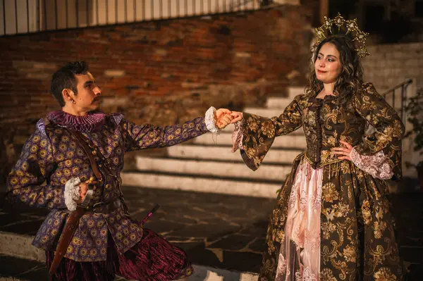 İspanyol sömürgesi döneminden flört eden bir çift, geleneksel İspanyol takım elbiseli bir adam mor ve pembe giyinmiş bir adam, ve prenses tarzı bir tacı olan güzel bir kız..