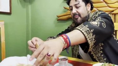 Lübnanlı bir adamın elleri Tabbouleh 'e eşlik etmek için pide ekmeğini alırken gülümseyerek geleneksel yemeğinin tadını çıkardığı yatay 4k videosu..