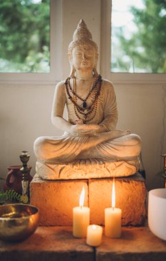 Budist mihrabının ayrıntıları. Mumlar, bitkiler ve ortasında kocaman bir Buda..