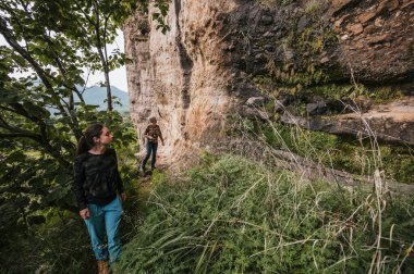 Anne ve kızı kırsal kesimde yürüyüş yaparken bir uçurumda mağara resimleri bulmuşlar, yürüyüş kıyafetleri giymişler..