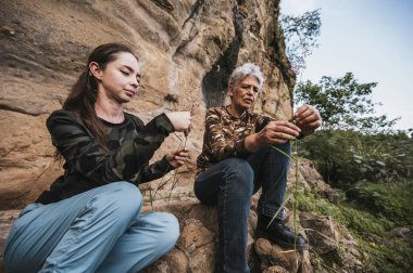 Anne ve kızı ormanda bir öğleden sonranın tadını çıkarıyor, bir uçurumda oturuyor ve ufka bakıyor..