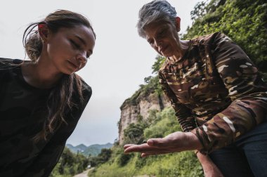 Anne ve kızı ormanda keşfe çıkıyor, bitkileri gözlemliyor.