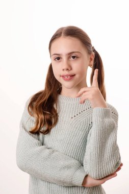 Cute kid raised her index finger while answering the question. Girl 10 years old, caucasian, blonde. Concept of study, idea, excellent student, find the answer. Schoolgirl.