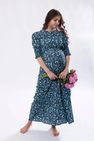 스튜디오 배경에 모란의 꽃다발과 드레스에 아기를 기다리는 코카서스 브루넷 — 스톡 사진