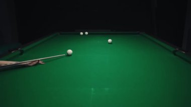Kadın bilardo oynuyor, topları kırıyor, odaklanıyor.