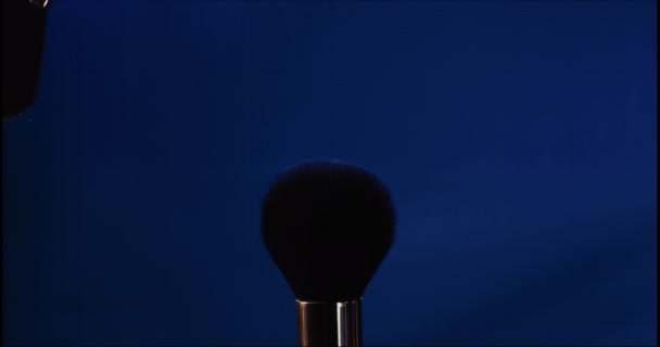 Zwei Make Pinsel Mit Blauem Puder Auf Schwarzem Hintergrund Stockvideo