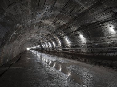 Eski terk edilmiş yeraltı sığınağında, kemerli tavanlı, karanlık, tüyler ürpertici büyük bir tünel. Tünelin sonundaki ışık kavramı.