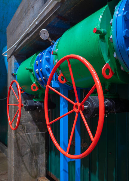 Plumbing pipe with regulation system and pressure sensor, two big red manual control ball valve of water which coming to power generator on the hydroelectric power plant