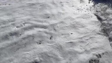 Beyaz köpüklü büyük güç dalgaları. Deniz fırtınalı. Büyük deniz dalgalarıyla kıyı şeridi. Köpükle sörf yapmak. Gün batımında güzel deniz manzarası, ağır çekimde köpüklü dalgalar.