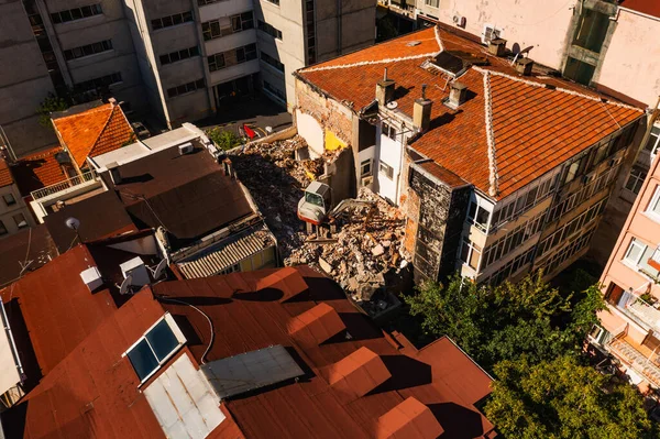 Demolition of old apartments in Turkey. Renovation of old buildings in the center of istanbul with construction equipment. Loader on the roof of the house for demolition