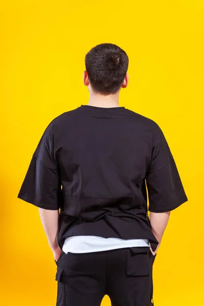 Tipo Con Una Camiseta Negra Sobre Fondo Amarillo Espalda Hombre — Foto de Stock