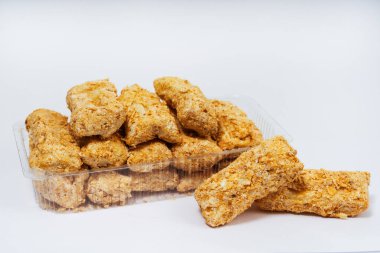 Beyaz arka planda serpiştirilmiş küçük tatlı kekler. Napolyon keki arka planda parçalara ayrılmış. Kırıntılar serpiştirilmiş küçük kekler.