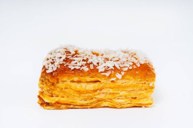 Beyaz arka planda serpiştirilmiş poğaça kurabiyeleri. Hindistan cevizi taneli, hafif arkaplanlı fırında un kekleri. Tatil için hamurdan renkli tatlılar