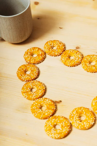 木のテーブルの上にゴマをかけた丸クッキー ゴマ入りの甘いクッキー 高カロリーの小麦粉スイーツ — ストック写真