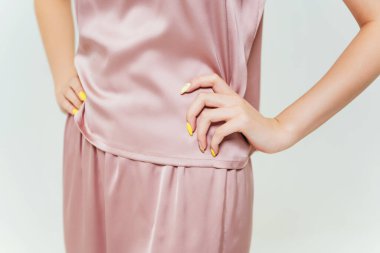 Pembe geceliğin ayrıntıları bir kızda. İpek kadın uykusunun fotoğraf çekimi bir kadına ayarlanmış. Kadın pijaması.