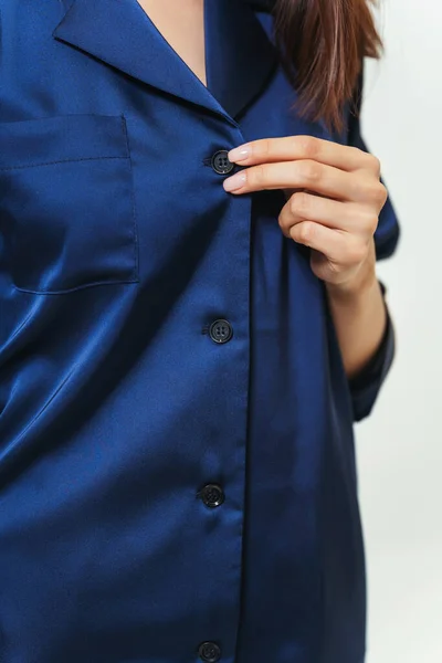 stock image details of a dark blue nightgown on a girl. photo session of a silk women's sleep set on a woman. women's colored pajamas