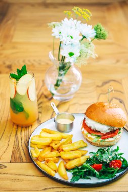 Biftek pirzolası ve bir kafede terasta patates kızartması. Kahve dükkanında fast food. yüksek kalorili burger