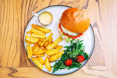 Biftek pirzolası ve bir kafede terasta patates kızartması. Kahve dükkanında fast food. yüksek kalorili burger