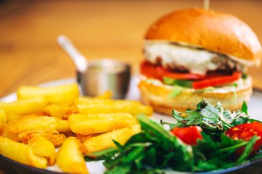 Biftek pirzolası ve bir kafede terasta patates kızartması. Kahve dükkanında fast food. yüksek kalorili burger
