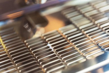 Endüstriyel kahve makinesinin üzerindeki koruyucu metal örgüsü. Sıvıları boşaltmak için delikli metal kaplama. Kahve makinesinde paslanmaz çelik levha.