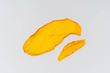 Beyaz arka planda kurutulmuş mango dilimleri. Pişirmek ve içmek için kurutulmuş mango. Hafif arkaplanda mango çipleri