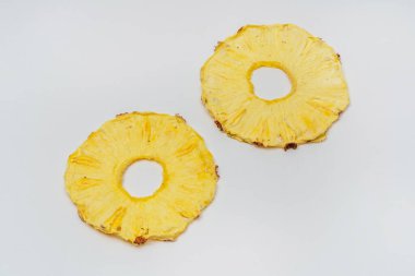 Beyaz arka planda kurumuş ananas dilimleri. Kurutulmuş ananas suyu yemek ve içmek için. Hafif arkaplanda ananas parçaları